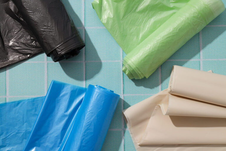 rolls garbage bags blue background top view (1)